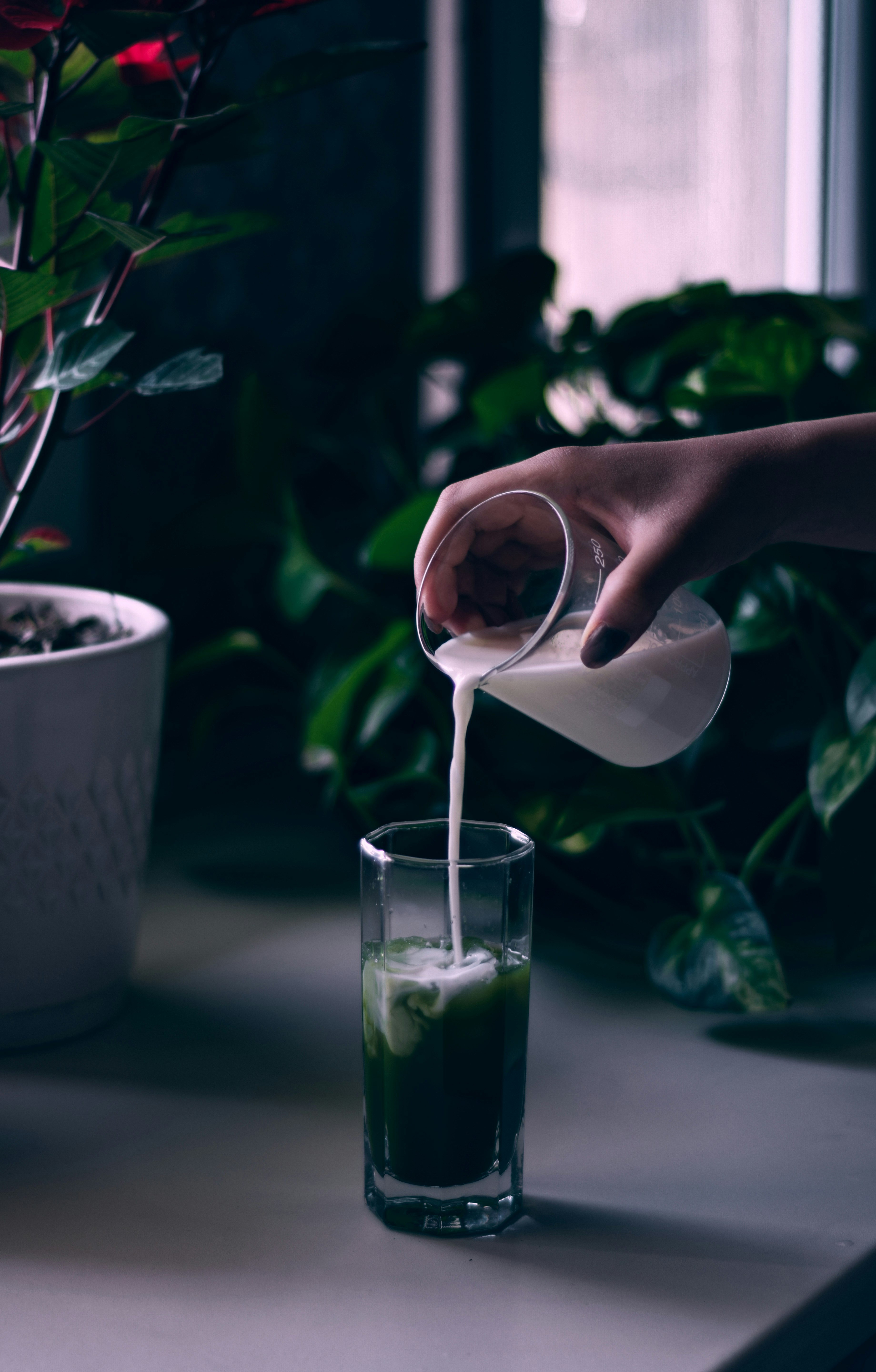 person pouring water on white ceramic mug